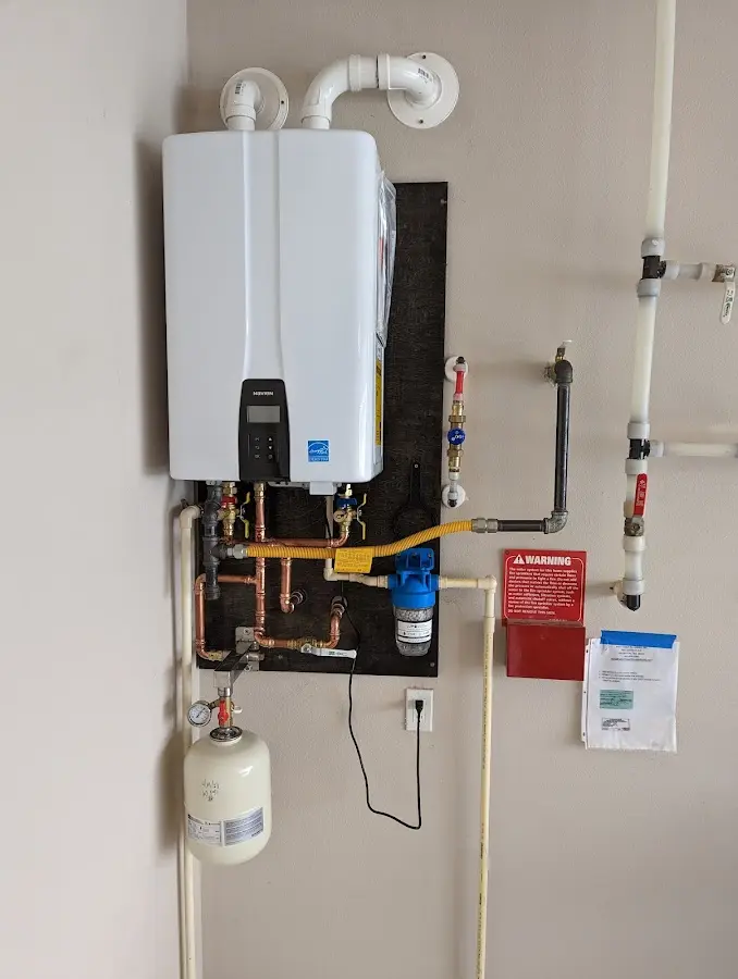 Professional plumber installing copper piping in a Carver home